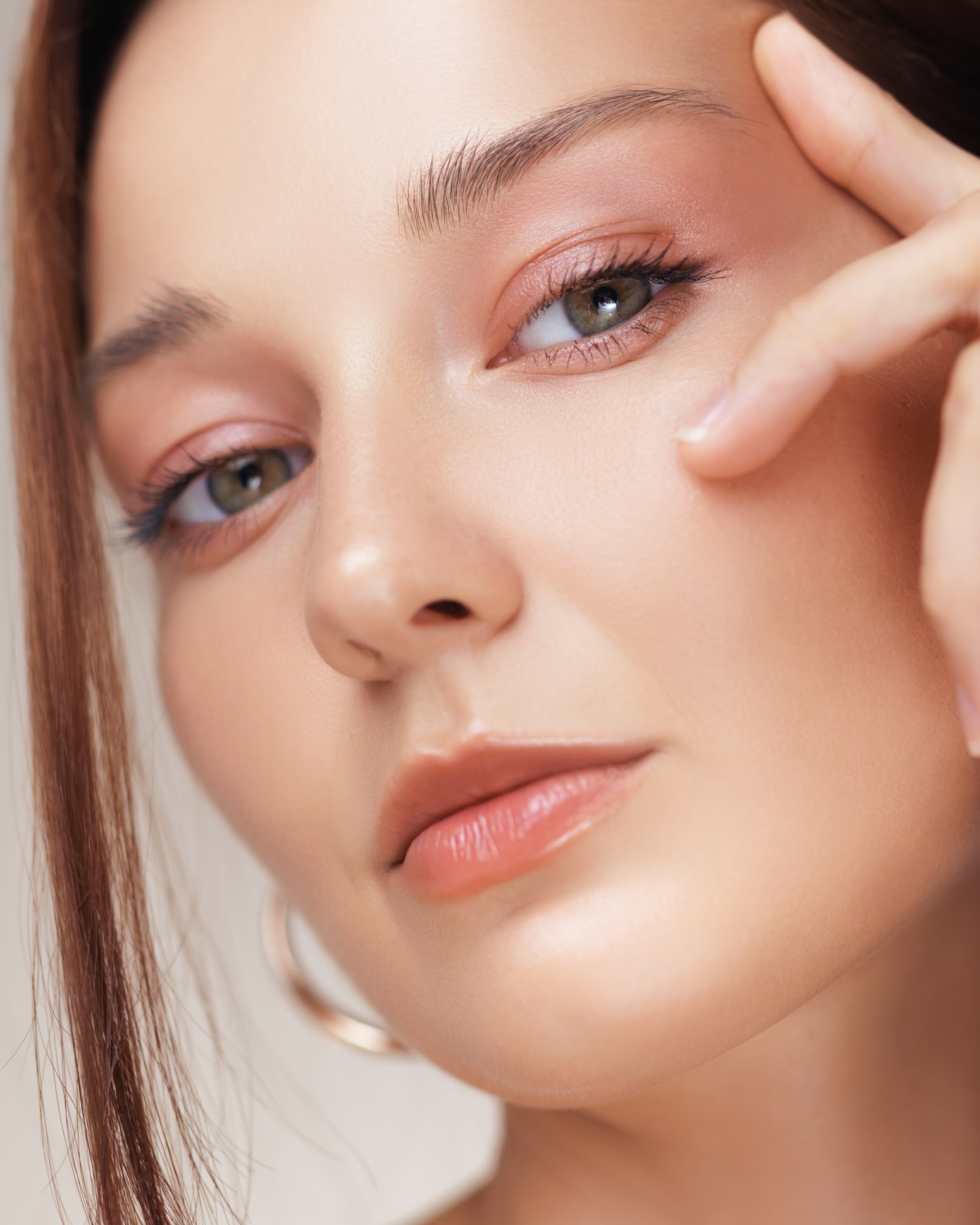 Close-Up Of Woman Touching Eye Area With Peach Makeup And Flawless Skin Premier Plastic Surgery in Newport Beach, CA