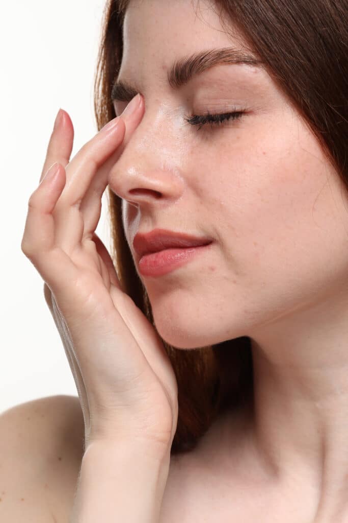 Beautiful woman with freckles on white background, closeup Premier Plastic Surgery in Newport Beach, CA