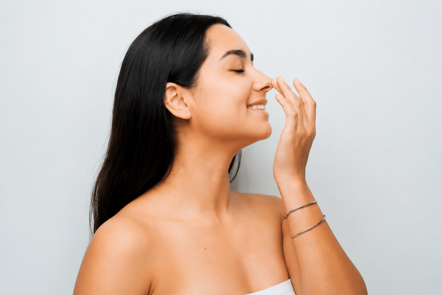 Woman touching her nose smiling after Rhinophyma surgery in Newport Beach, CA