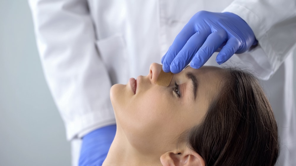 Doctor examining a patient's nose for rhinoplasty in Newport Beach, CA Doctor examining a patient's nose for rhinoplasty in Newport Beach, CA